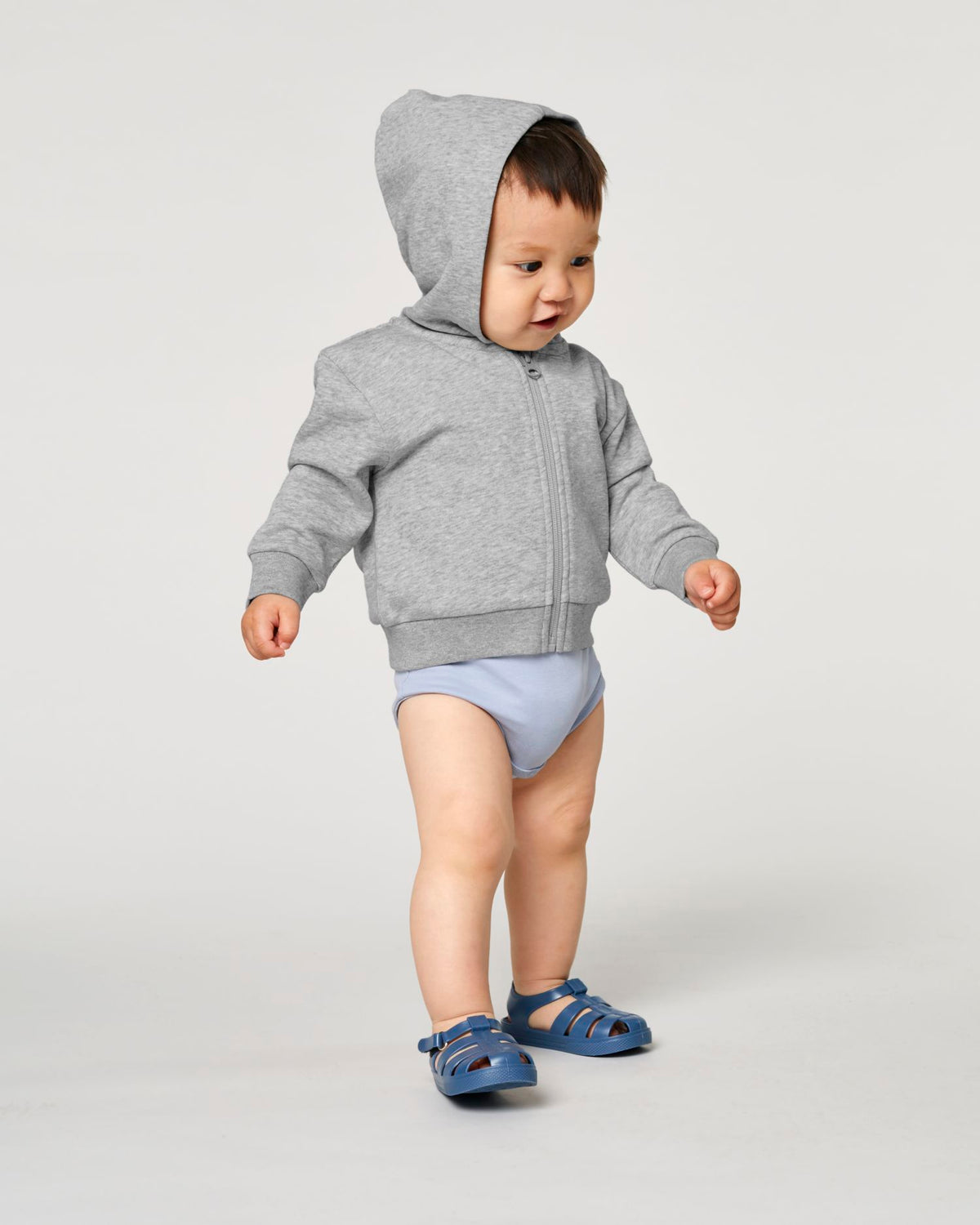 Baby trägt einen blanken Baby Zip-Hoodie in Heather Grey mit Regular Fit – Stanley/Stella Baby Connector STSB105 zum Bedrucken oder Besticken.