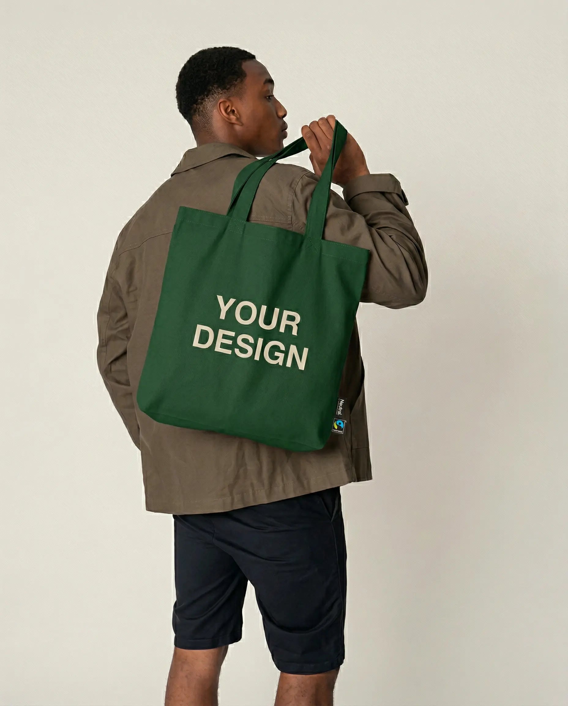 Comfortable fair trade sweatshirt made of organic cotton, embroidered with a logo for B2B use. The model shows the sustainable teamwear with high-quality sample embroidery 'Your Logo' on the left chest.