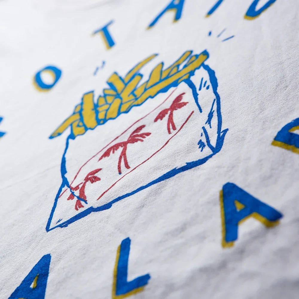 Nahaufnahme eines bunten Siebdruckmotivs mit stilisiertem Vogel und Schriftzug in Blau, Gelb und Rot auf einem Shirt, Beispiel für Textilveredelung im Siebdruck