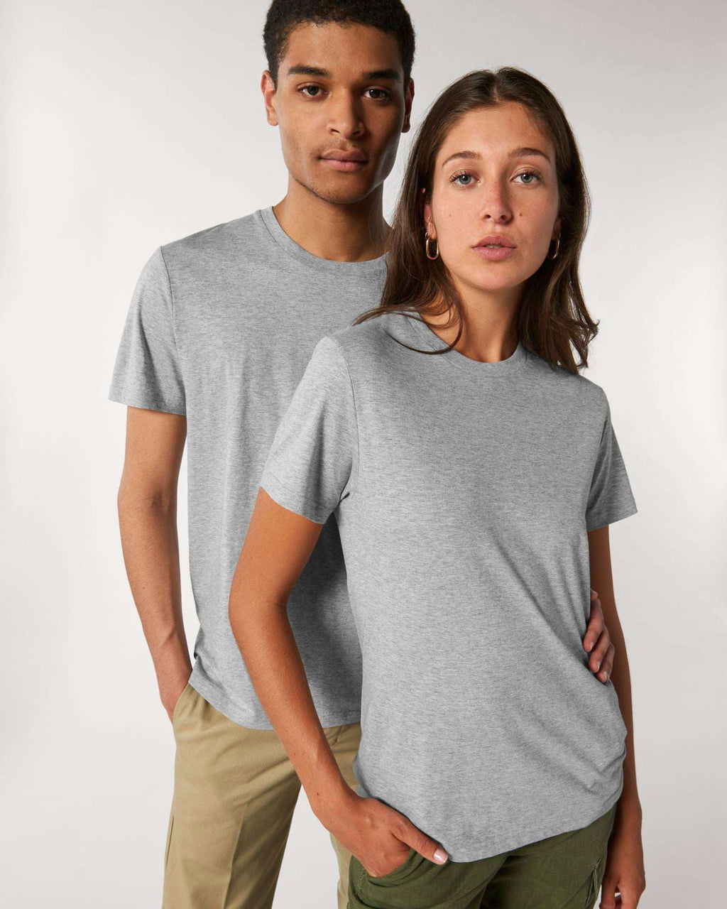 Zwei Models tragen das unbedruckte Stanley/Stella Rocker Unisex-T-Shirt in Heather Grey – einen Rohling zum Bedrucken oder Besticken.