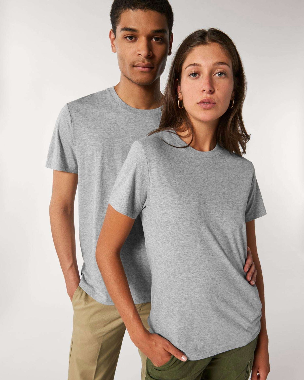 Zwei Models tragen das unbedruckte Stanley/Stella Rocker Unisex-T-Shirt in Heather Grey – einen Rohling zum Bedrucken oder Besticken.