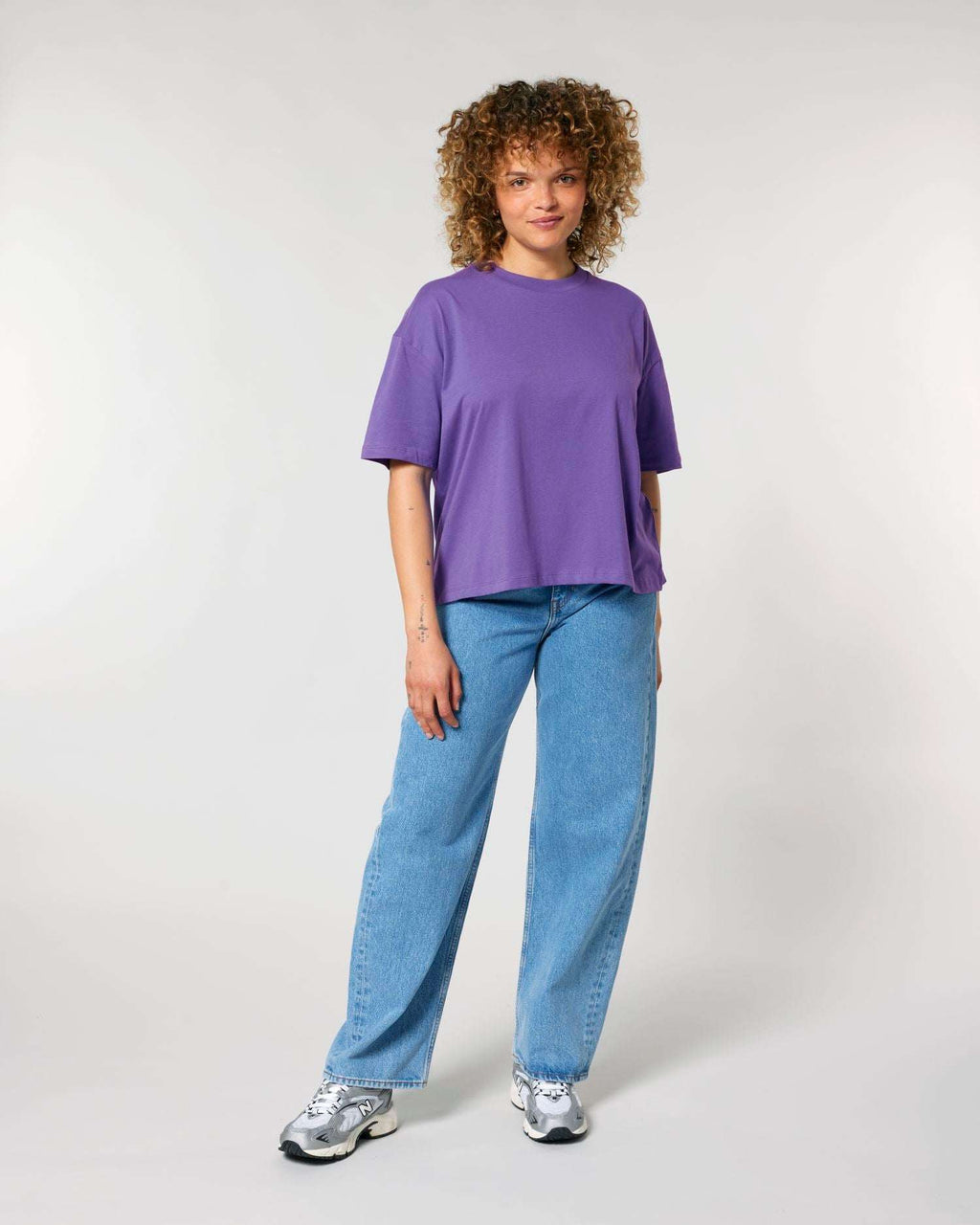 Frau trägt das unbedruckte, weit geschnittene Stella Nova Damen-T-Shirt von Stanley/Stella in Purple Love – ein Rohling zum Bedrucken oder Besticken.