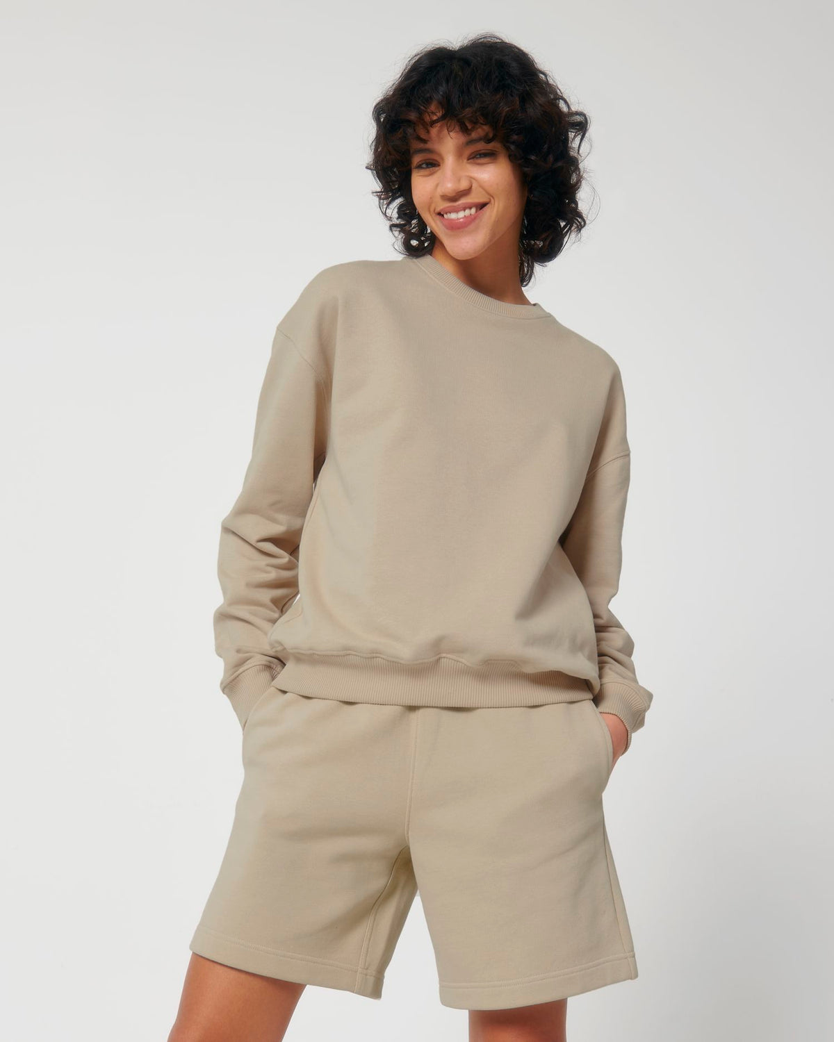 Frau trägt ein blankes Unisex Oversize Sweatshirt in Desert Dust mit Boxy Fit und Rundhalsausschnitt – Stanley/Stella Ledger Dry STSU798 zum Bedrucken oder Besticken.