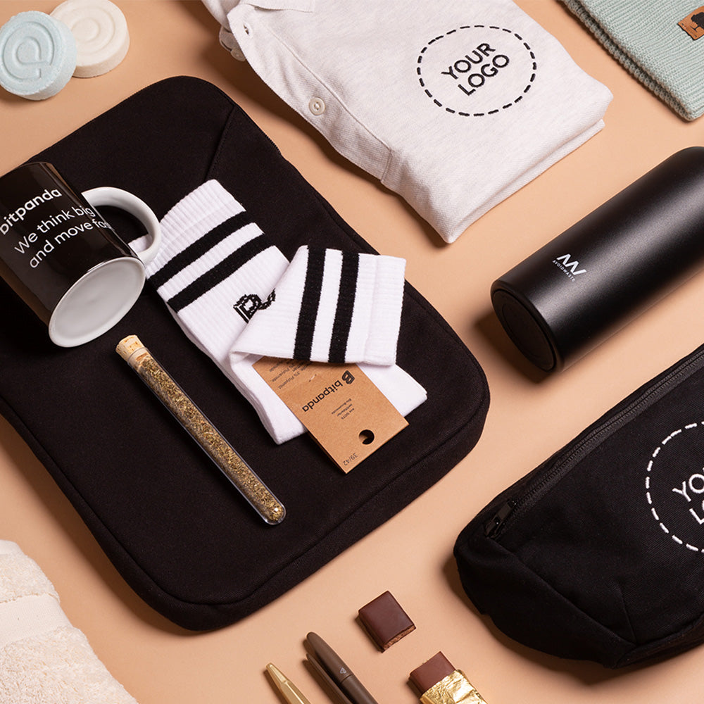 Flatlay mit schwarzer Tasche, Tasse, gestreiften Socken und Pflegeprodukten, Beispiel für ein individuelles Weihnachtsgeschenk Set für Mitarbeiter